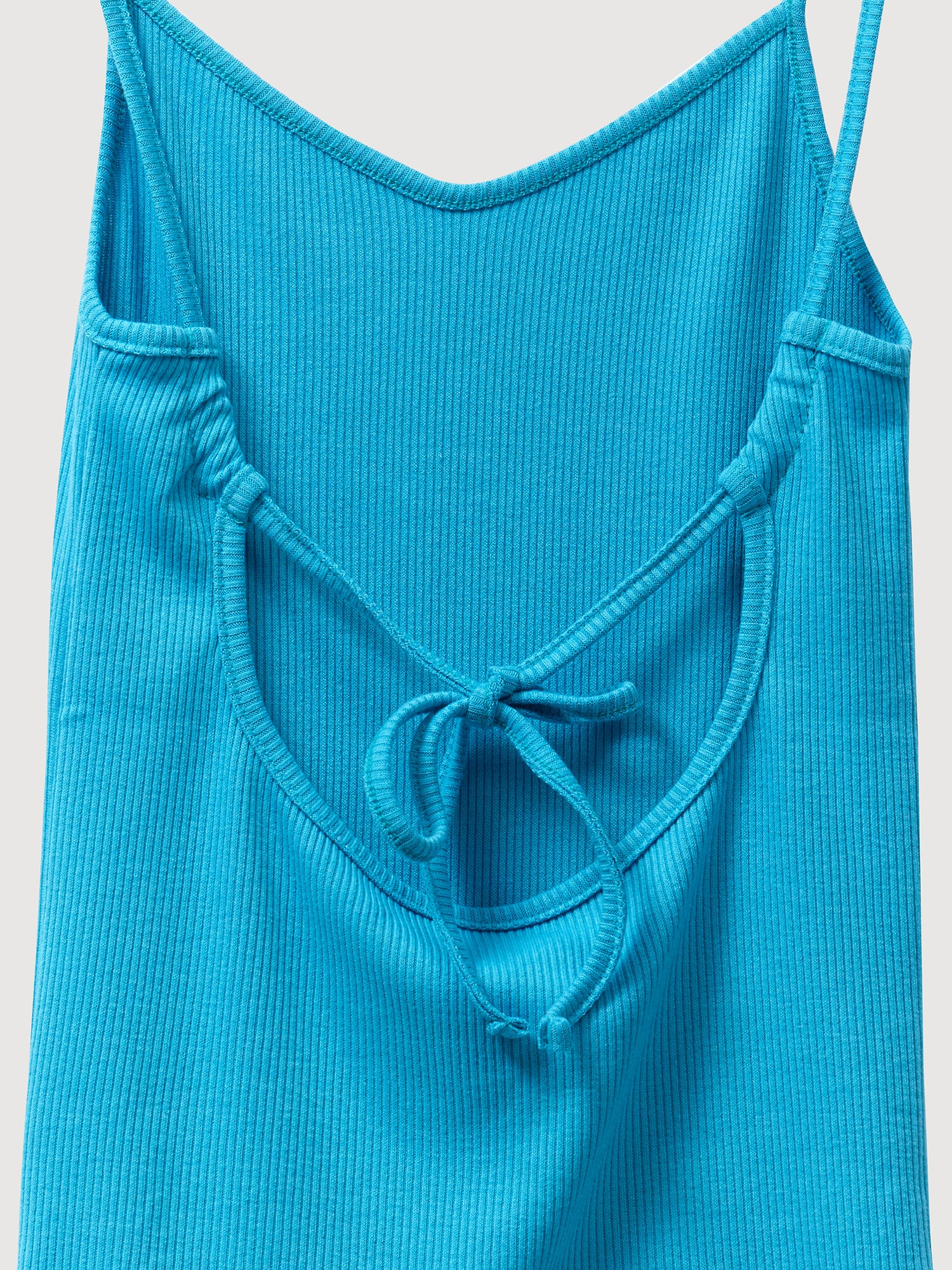 A close-up of the adjustable spaghetti strap on the backside of the blue tank top in this captivating shot.