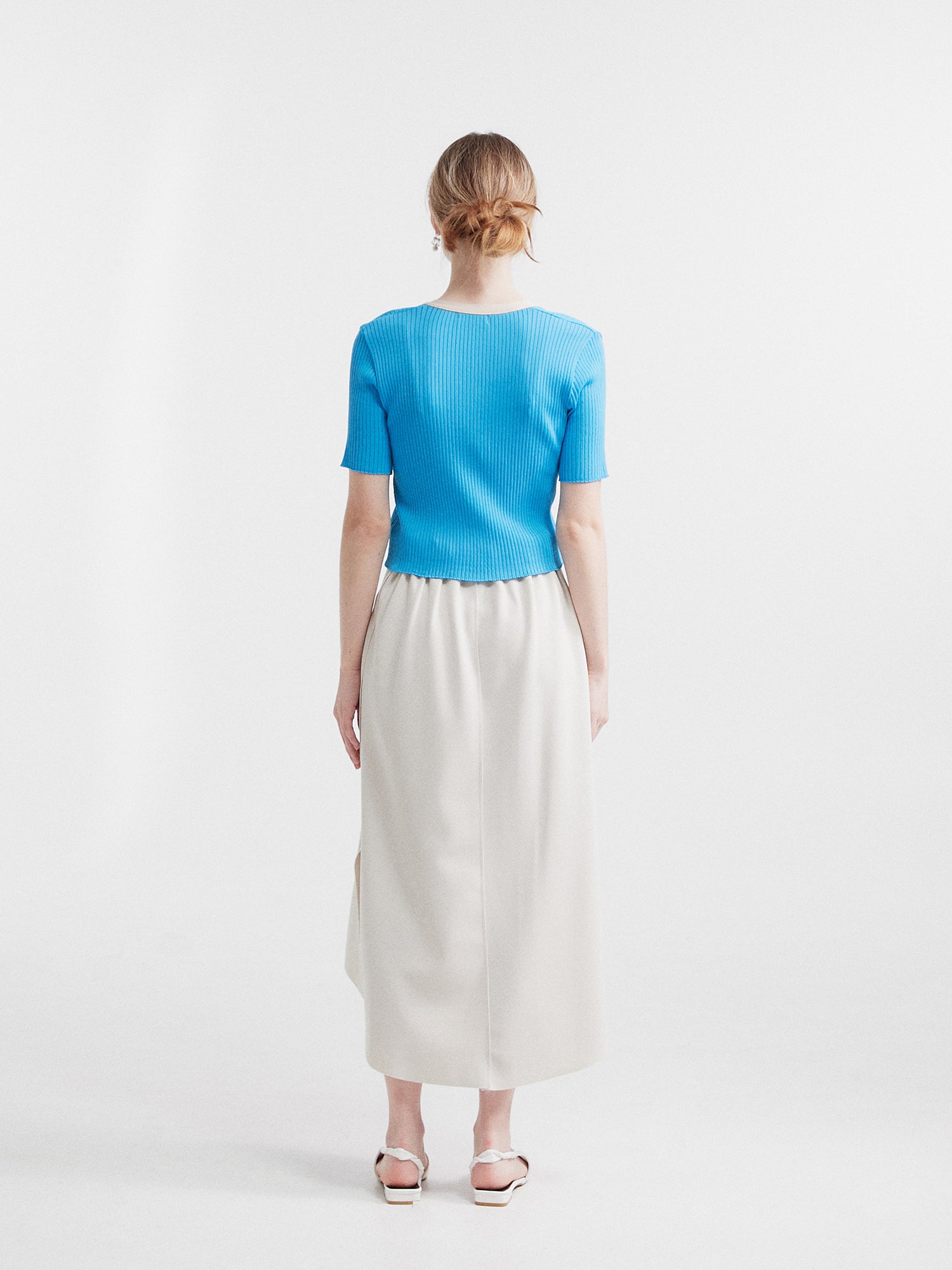 A back view of the blue contrasting trim cardigan showcasing the backside fit of the cardigan.