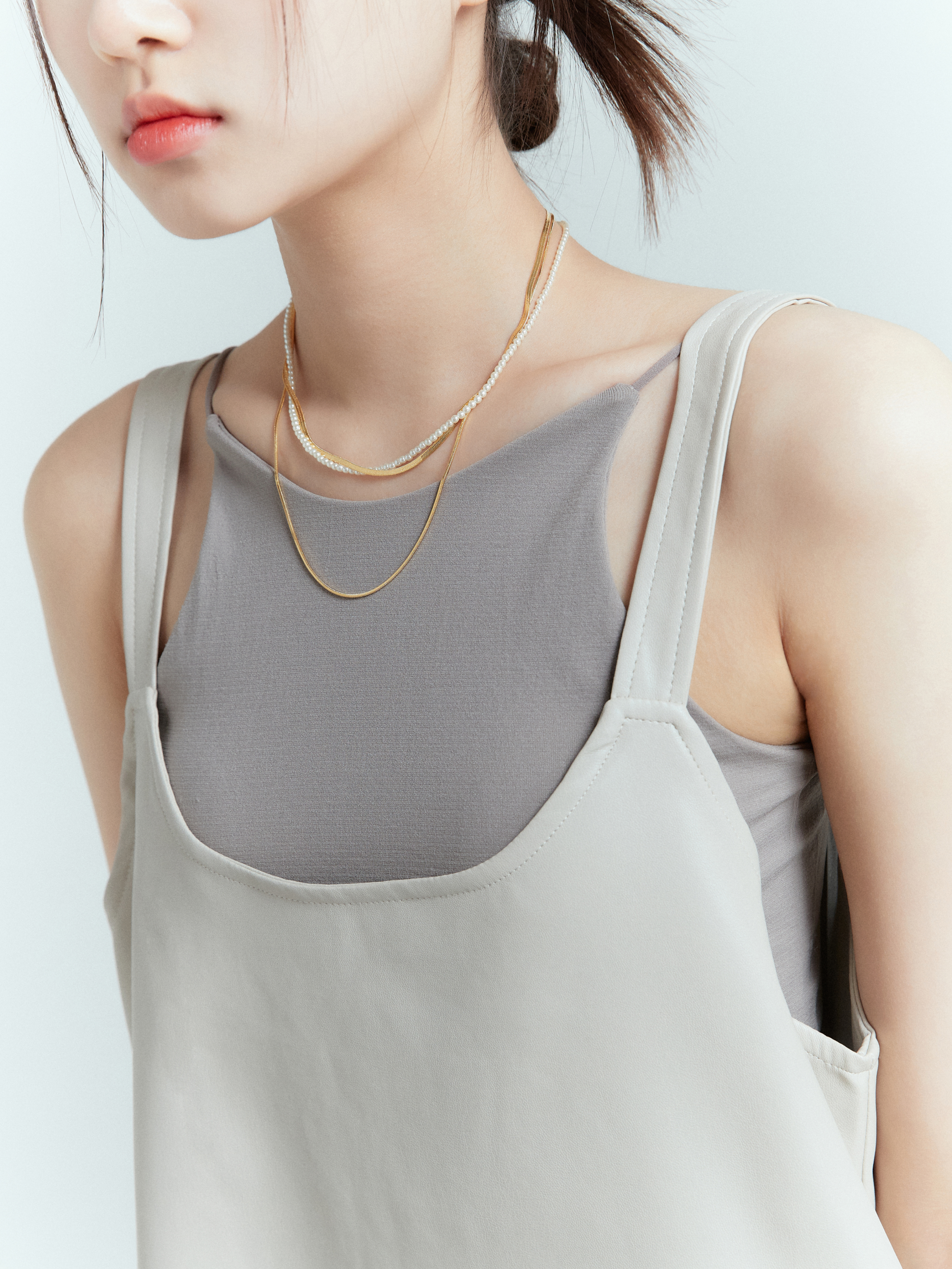 A close-up shot of the spaghetti strap tank, showcasing Korean street fashion, providing a detailed view of the intricate design of the tank top.