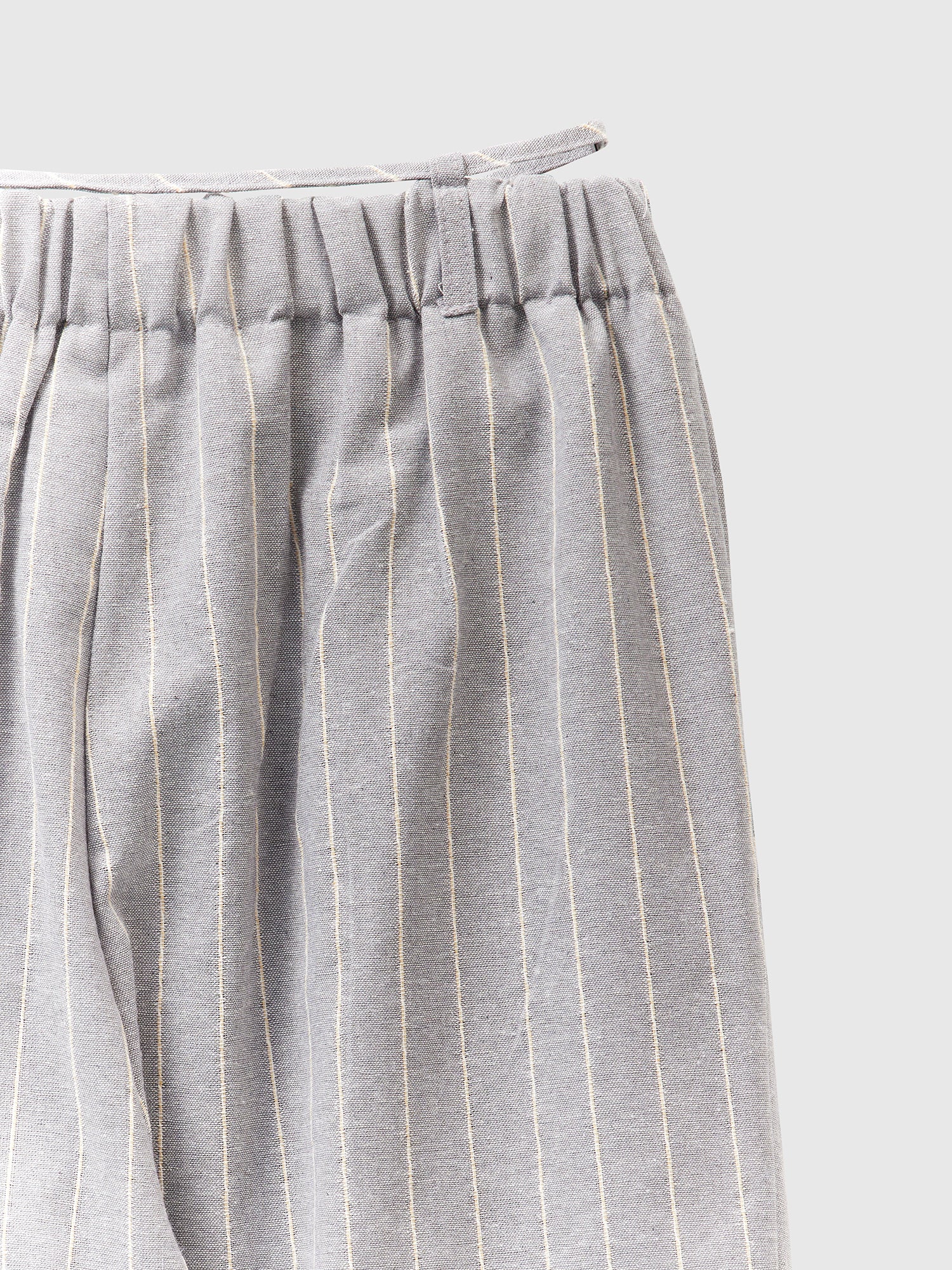 A close-up shot of the striped belt-tie trouser highlighting the elastic waist of the trouser.