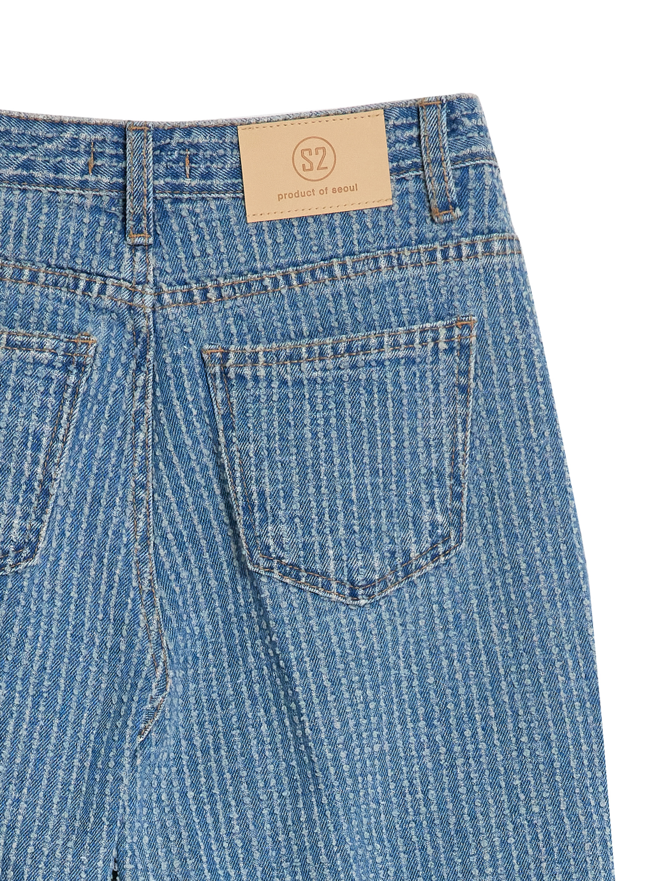 In a close-up view, the back side of the striped jeans takes center stage, revealing the intricate details of the striped fabric and showcasing the stylish back pockets.