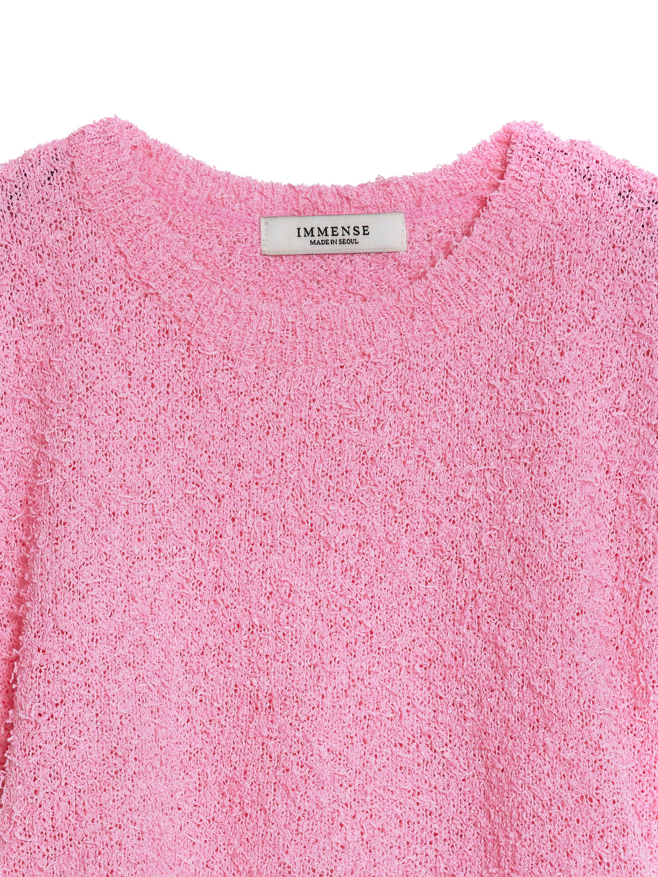 A close-up of the pink fuzzy knit top, highlighting its textured fabric.