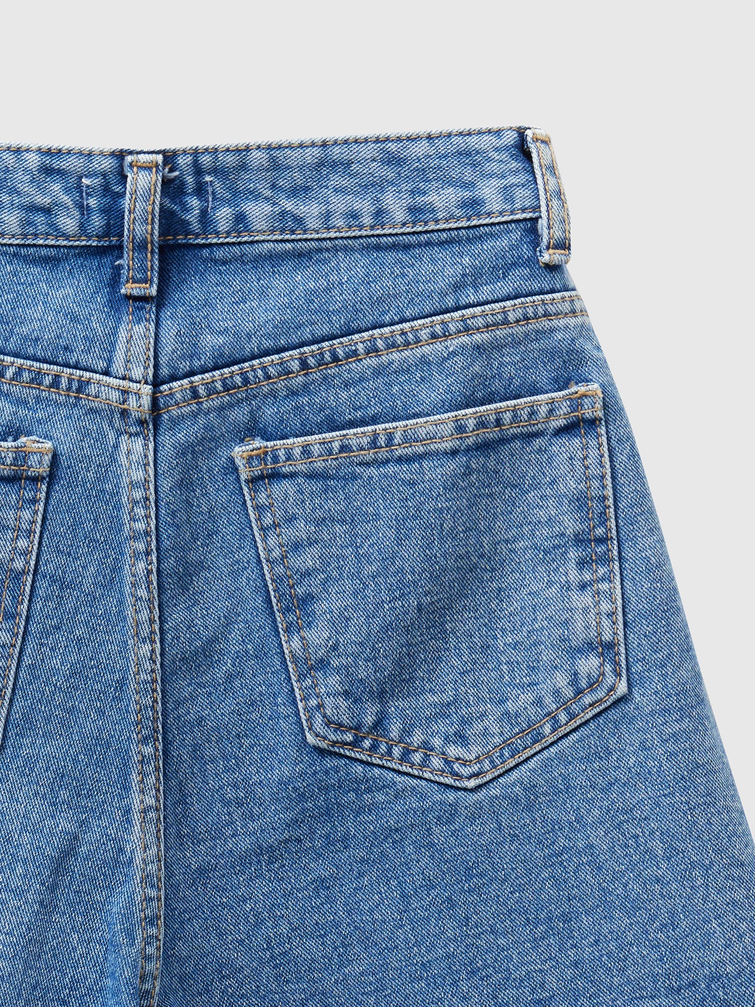 A closer look of the jean shorts with a zoomed-in shot, accentuating the intricate design of the back pockets.