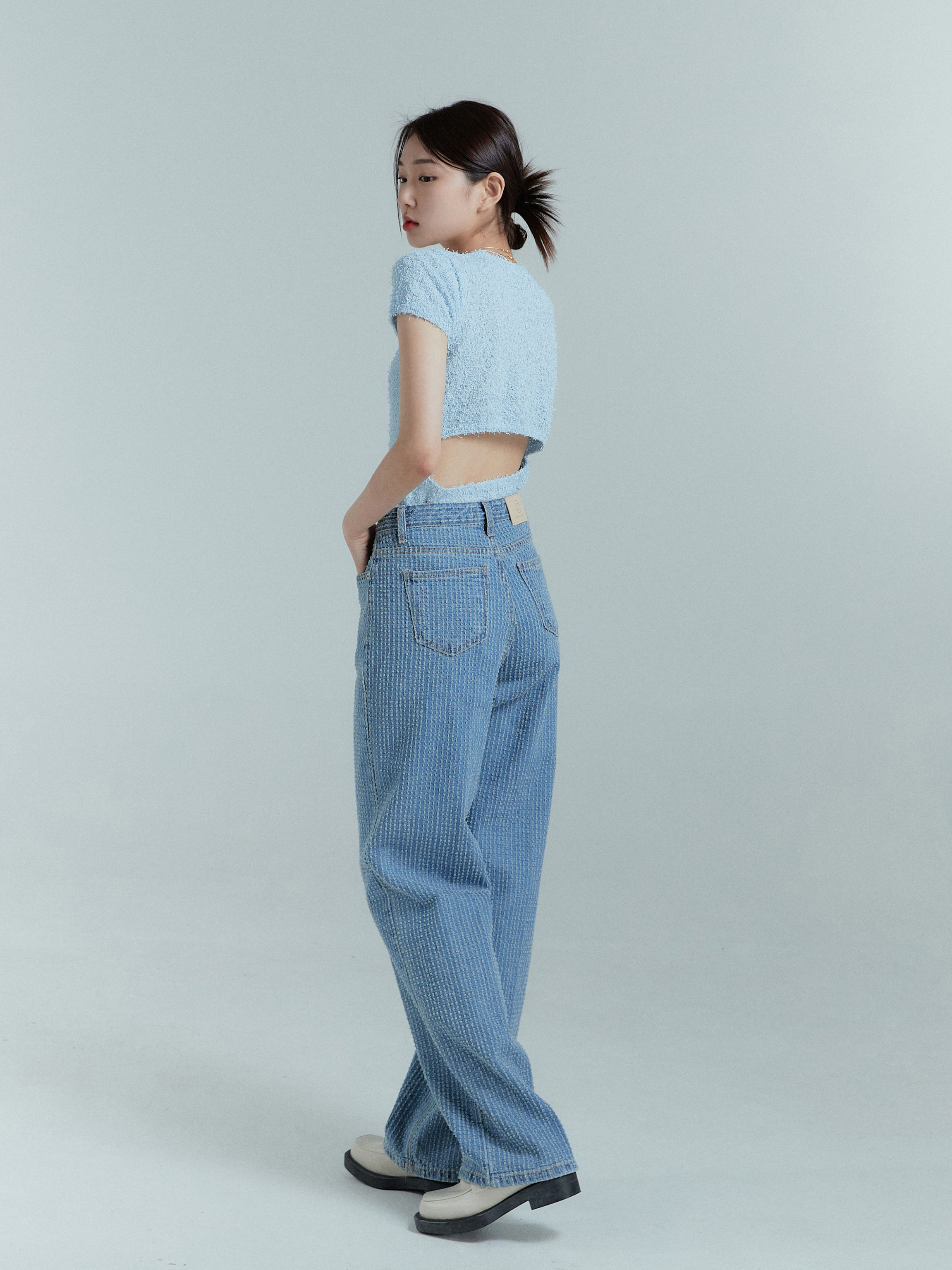 Back view of the model wearing the striped jeans showcasing the back pocket details.