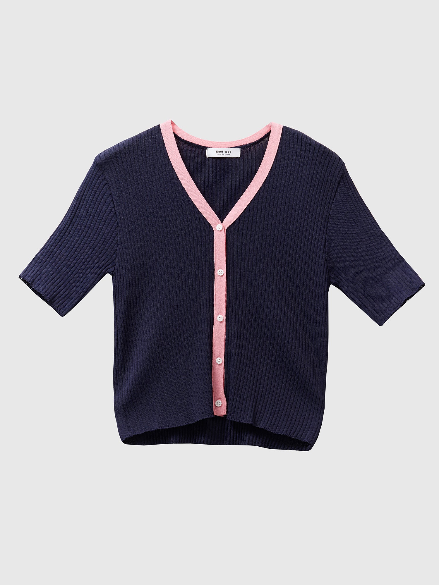 Product detailed shot of the navy contrasting trim cardigan with the pink trim detail on the edges.