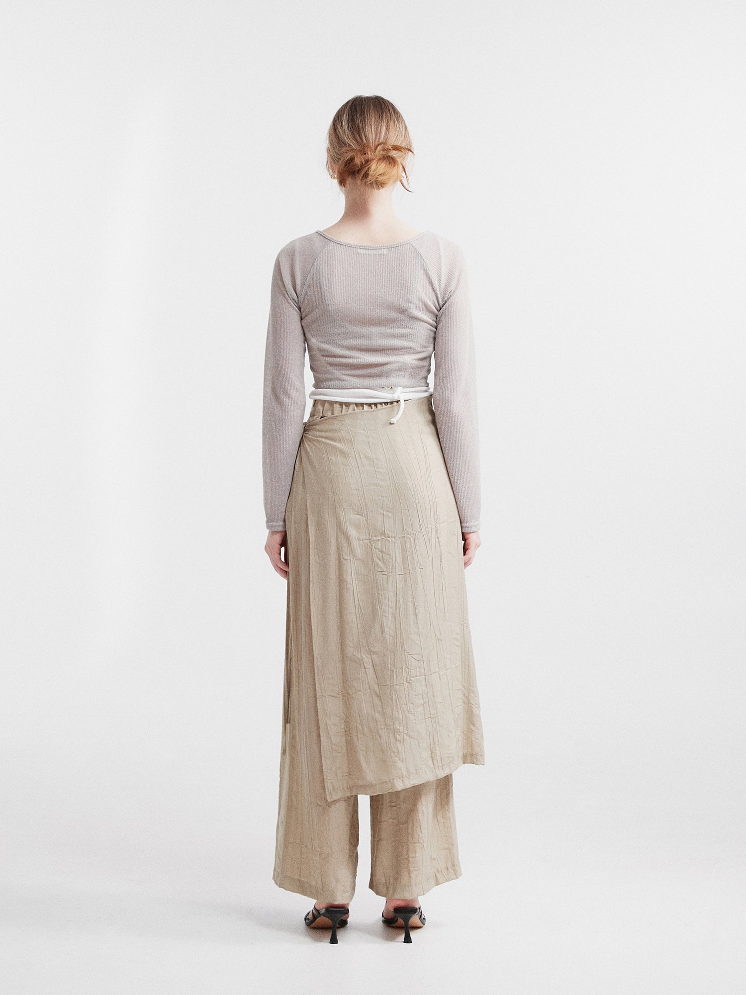 Back view of the model wearing the layered skirted pants showcasing the back design of the pants.