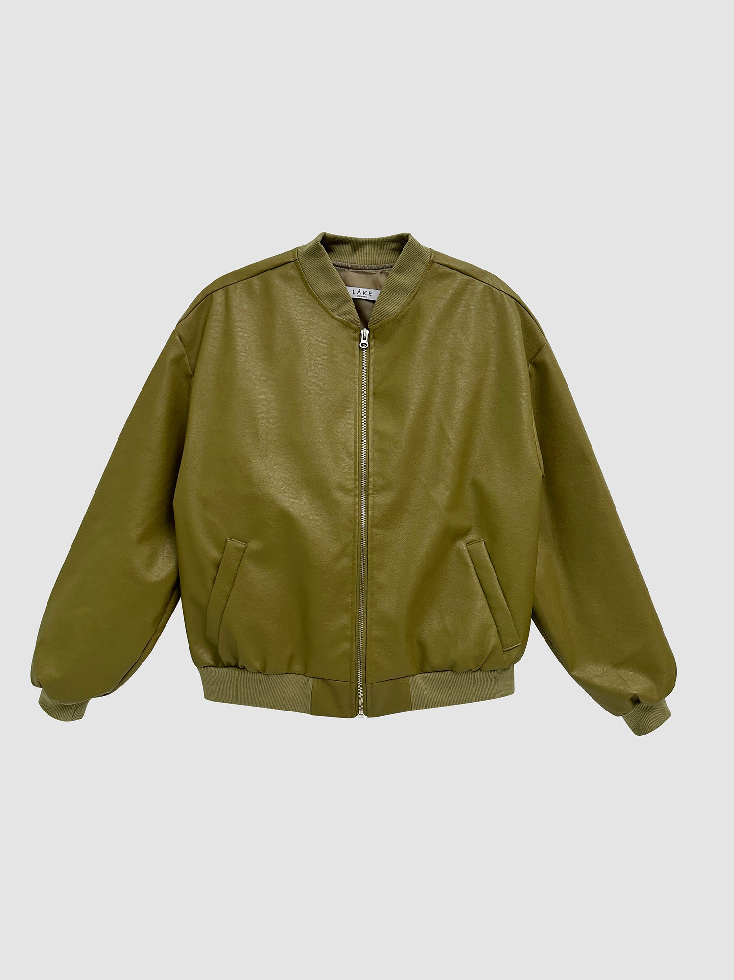 Product detailed view of the sage leather bomber jacket with gray backdrop.