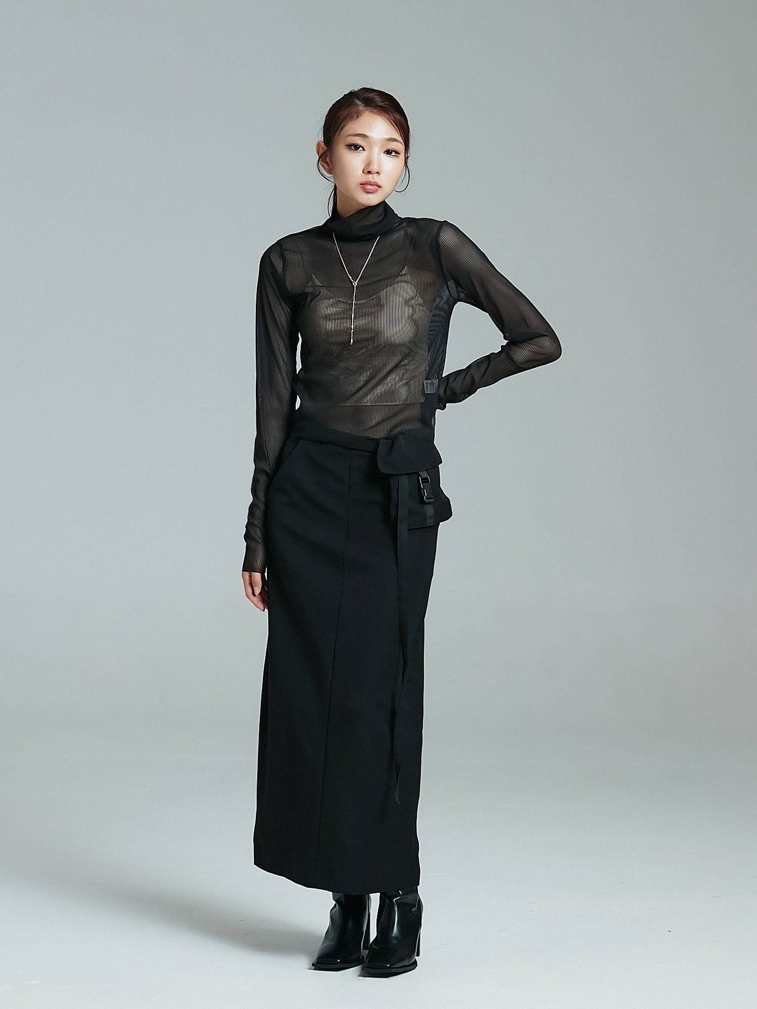 Full-shot of the model wearing the black mesh turtleneck paired with maxi skirt.