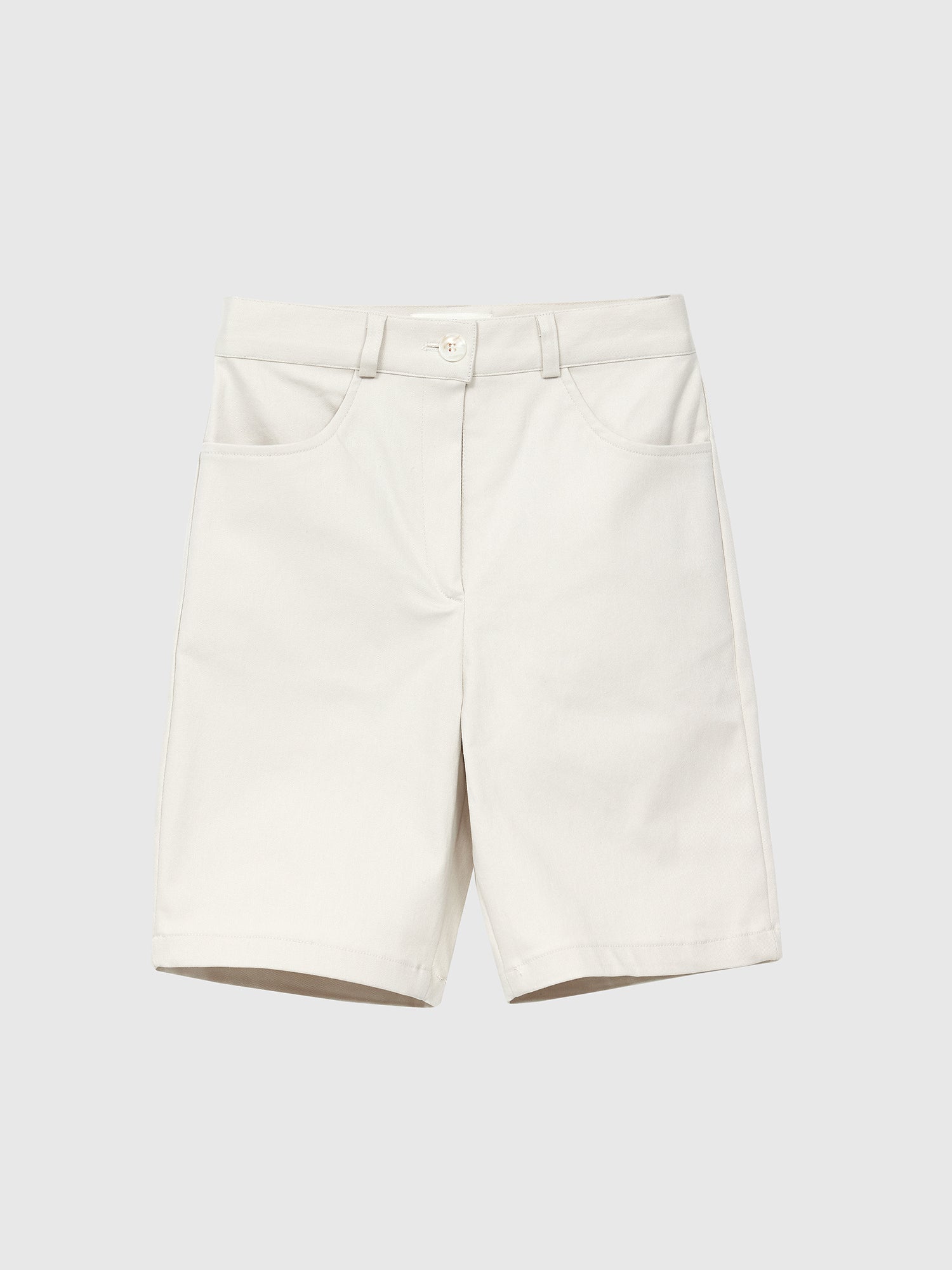 Front detailed view of the ivory mid-length shorts with gray backdrop.