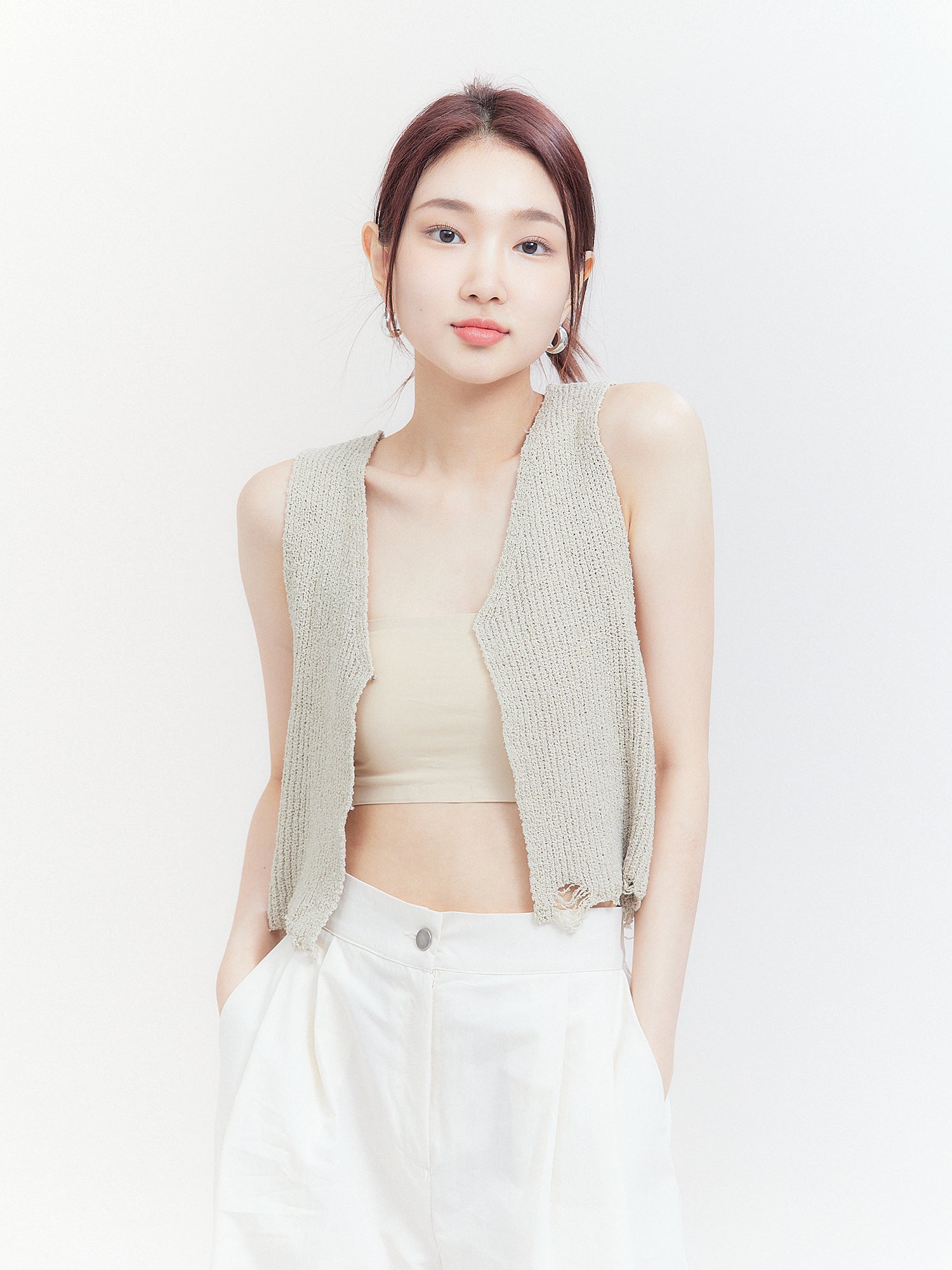 In a frontal view that captures the essence of Korean street fashion, the model dons the open-front tank top, emphasizing the alluring open design of the garment.