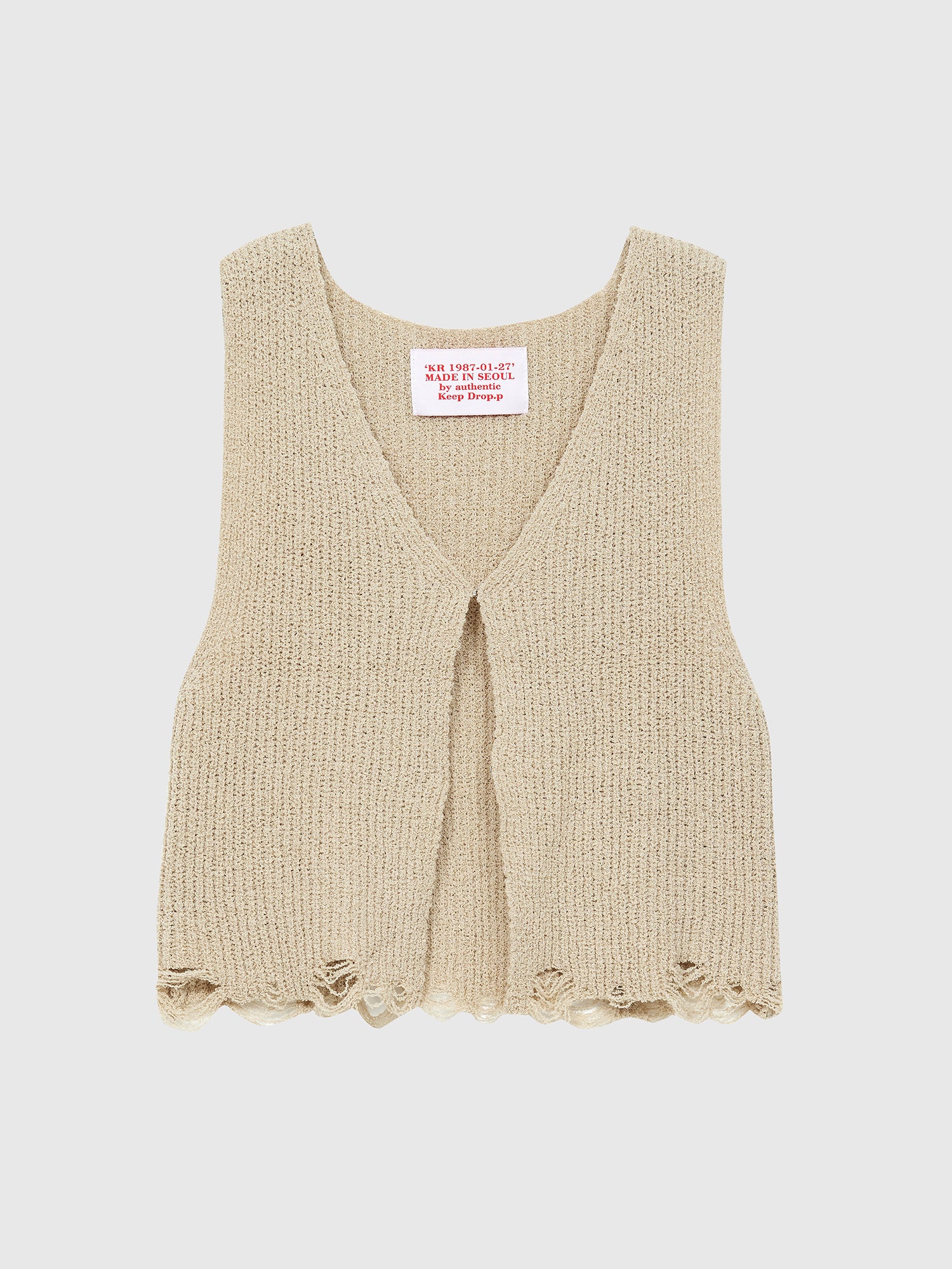 A detailed view of the Korean aesthetic inspired beige open front tank top against a gray backdrop, highlighting its intricate design and versatility for Korean aesthetic outfits.