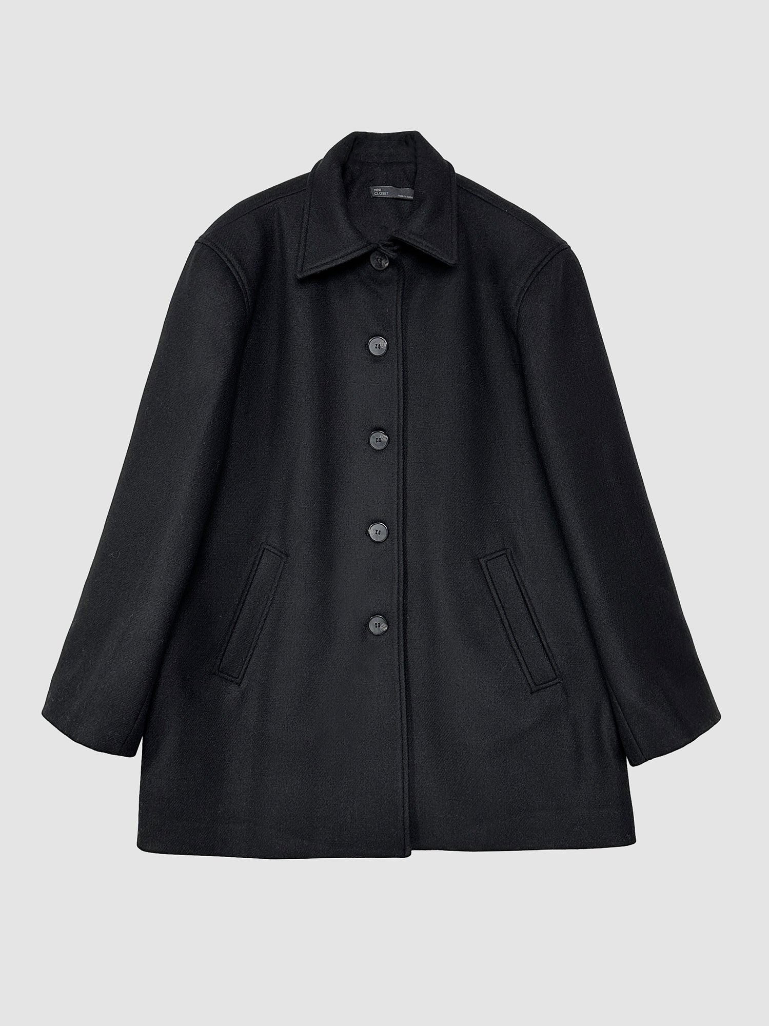 Frontal detailed view of the black 100% wool coat, capturing the sophisticated style inspired by Korean fashion.