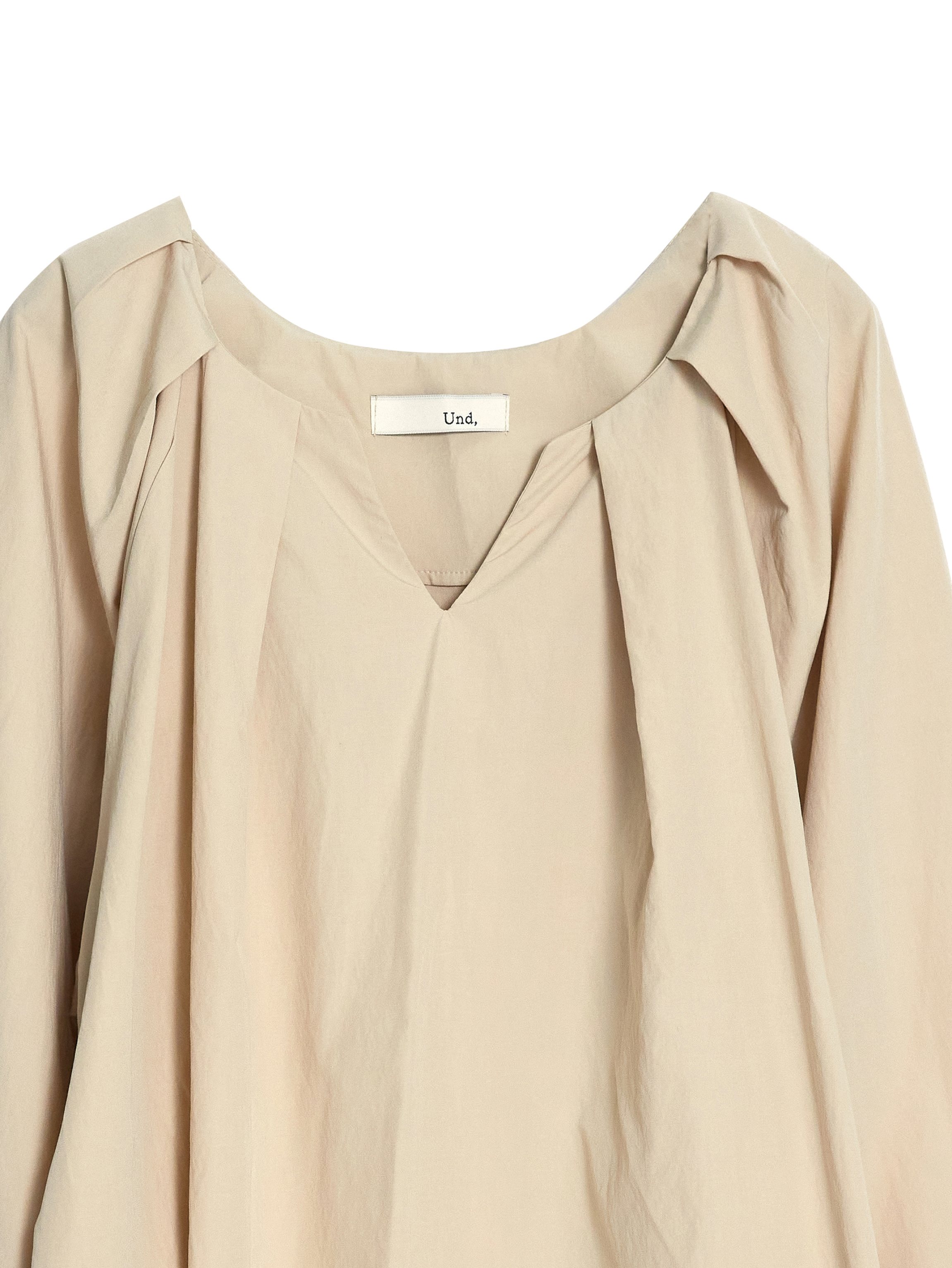 A close-up shot of the raglan sleeve blouse highlighting the front V-neck and pleated detail of the blouse.