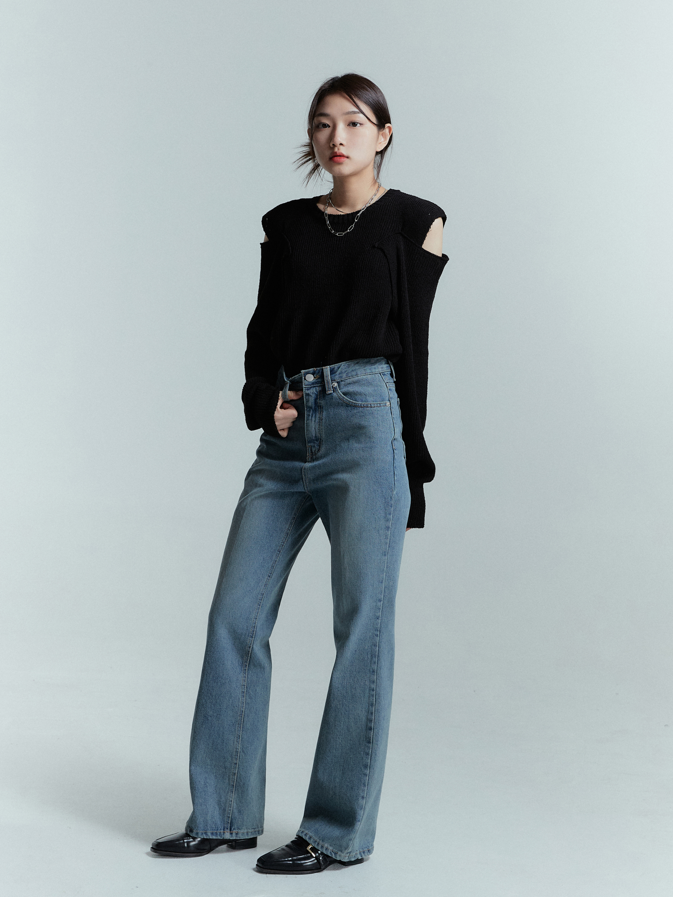 A tilted angle of a model wearing the wide leg jeans that is a color dark denim.