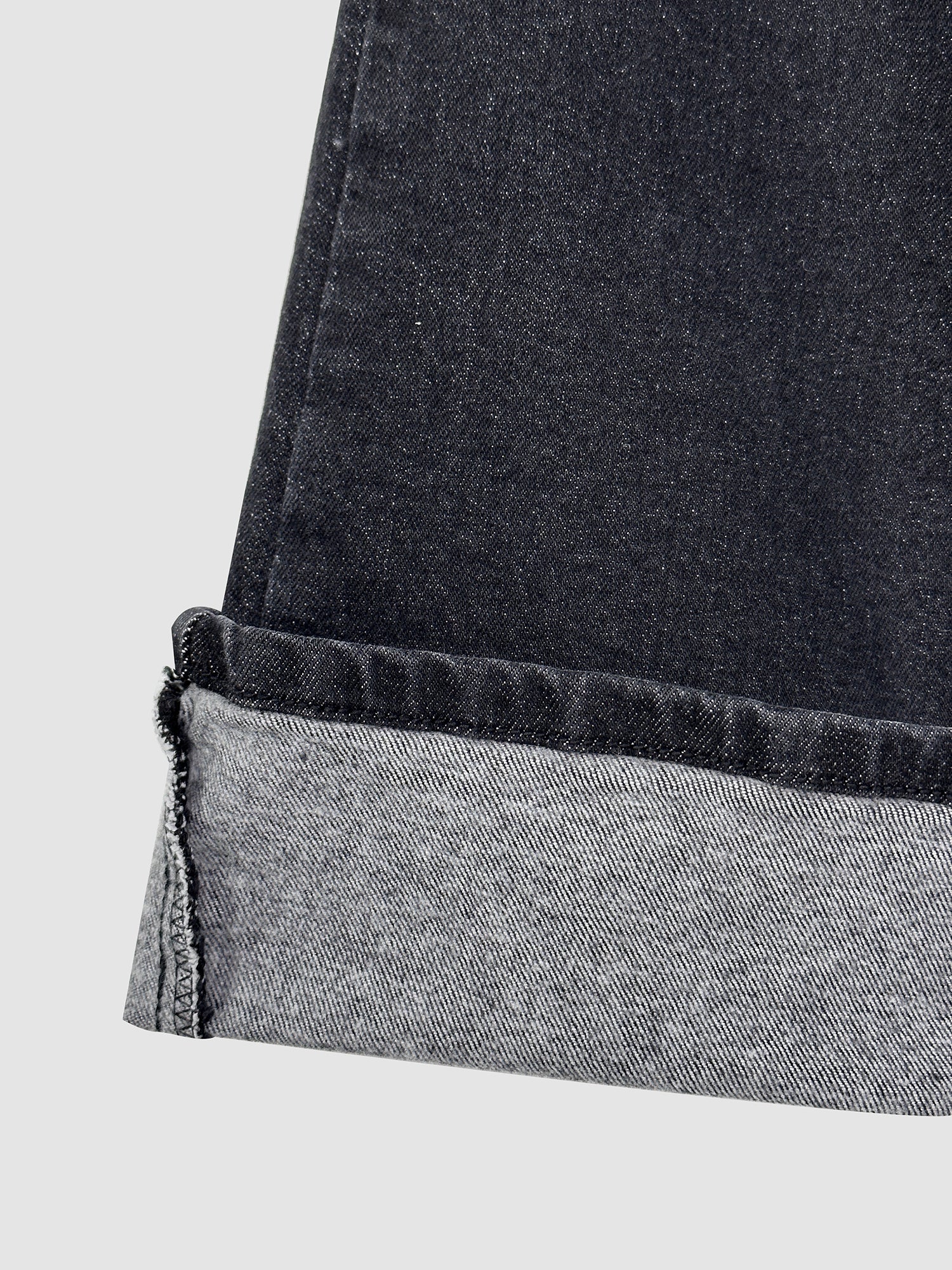 A close-up capture of the folded hem of the skinny flare jeans, highlighting the intricate fabric and stitching details.