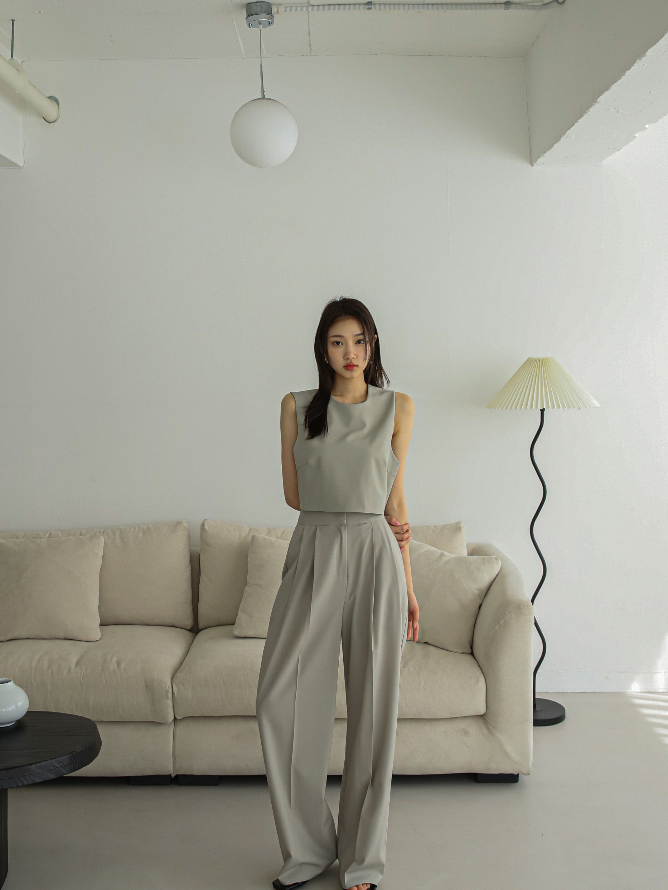 A long shot captures the model wearing the sleeveless blazer, elegantly paired with the matching trouser set, creating a harmonious and stylish ensemble.