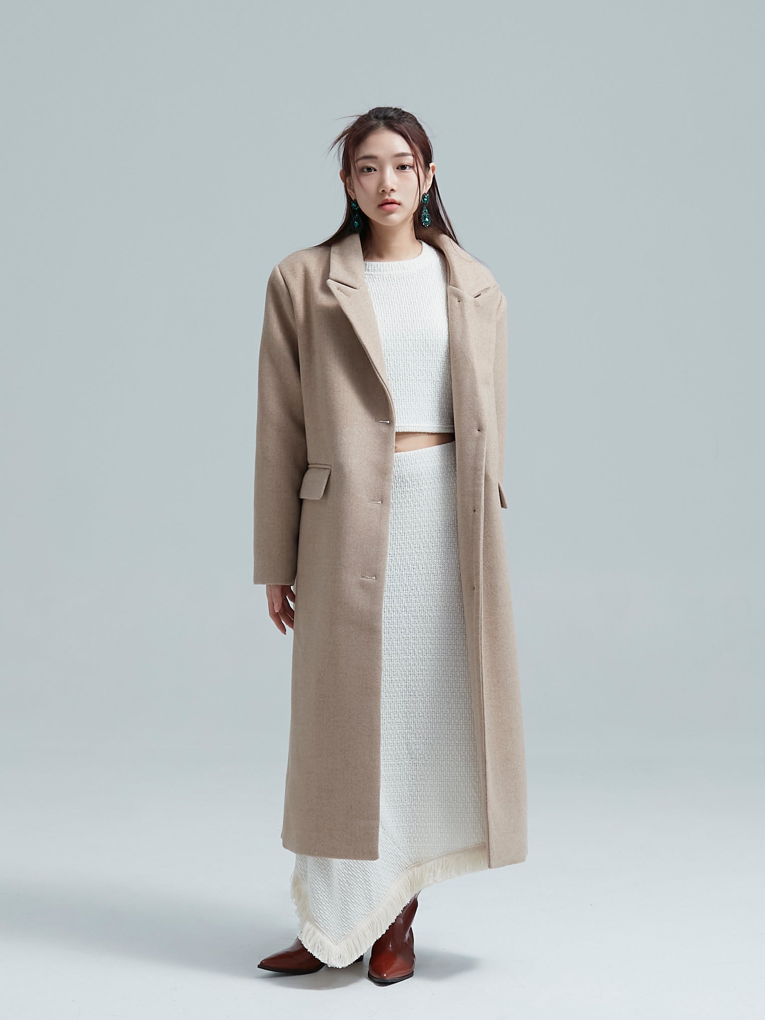 A woman is standing straight with the korean aesthetic wool coat.