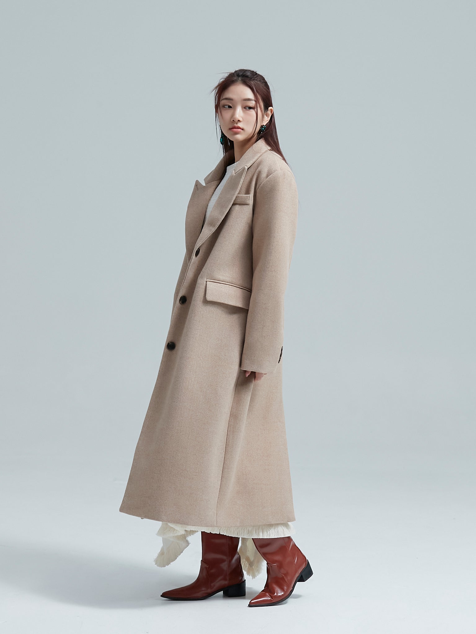 Model is posing to the side showing off the korean aesthetic wool coat that she's wearing.